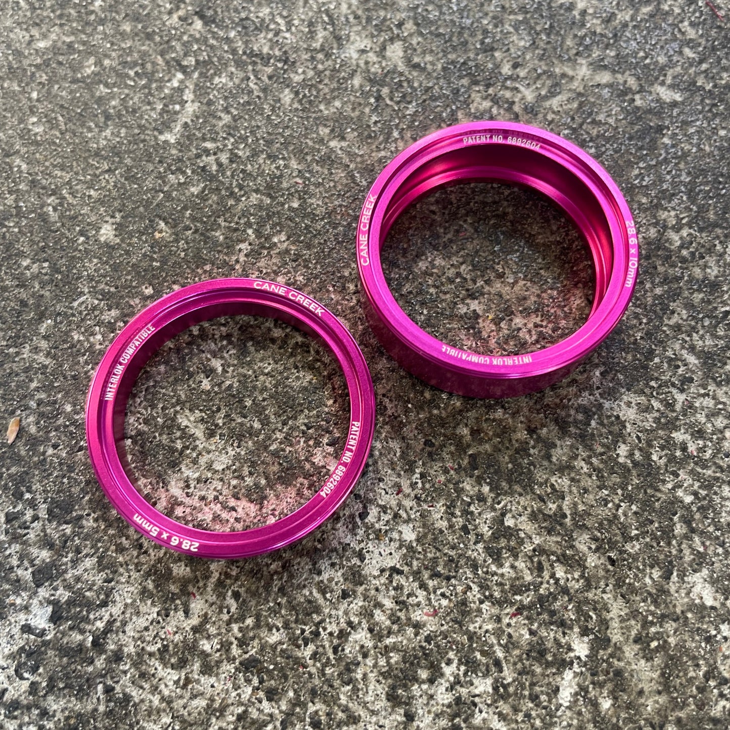 Two purple metal rings on a textured gray surface